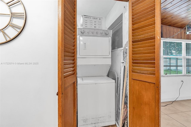 washroom featuring light tile patterned flooring and stacked washer and dryer