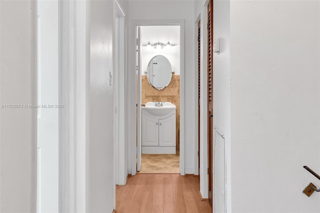 hall featuring sink and light hardwood / wood-style flooring