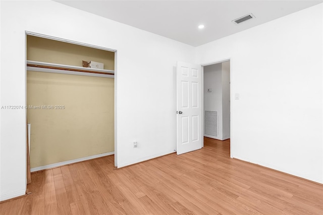 unfurnished bedroom with light hardwood / wood-style floors and a closet