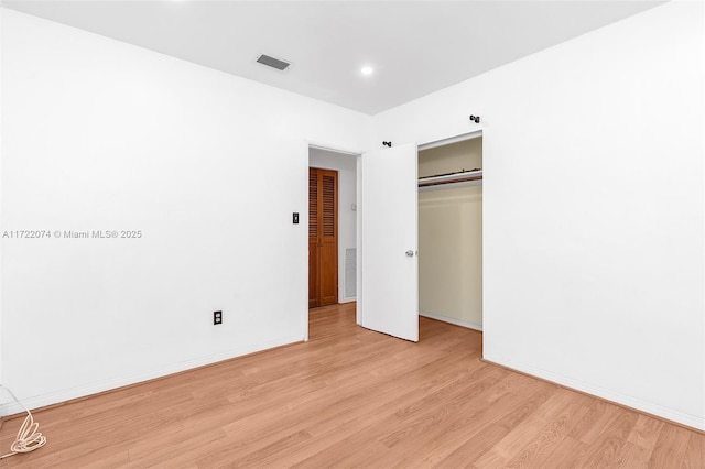 unfurnished bedroom featuring light hardwood / wood-style flooring and a closet