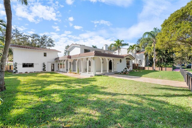 rear view of house with a fenced in pool, a garage, and a patio area