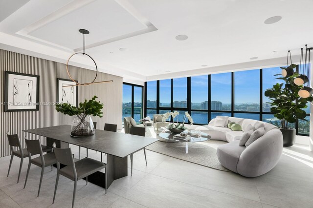 dining room with plenty of natural light, a water view, and a wall of windows