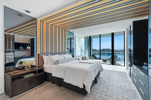 bedroom featuring a water view, access to outside, wallpapered walls, and expansive windows