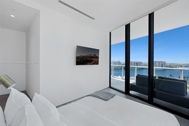 bedroom with concrete floors and floor to ceiling windows