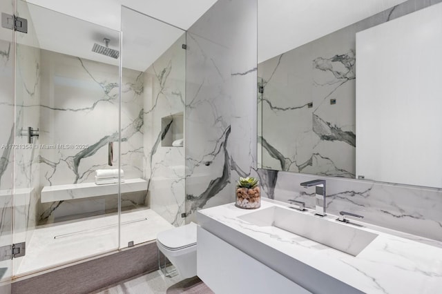 bathroom featuring a shower with door, vanity, and toilet