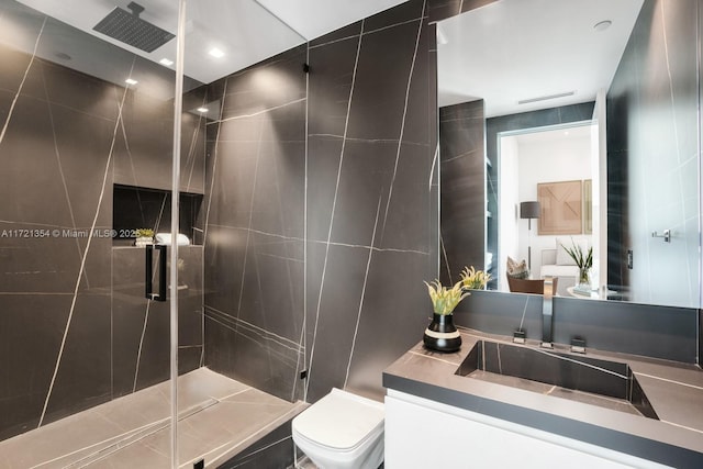 bathroom with vanity, toilet, an enclosed shower, and tile walls