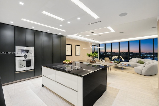 kitchen with a large island, white cabinetry, hanging light fixtures, black electric stovetop, and light tile patterned flooring