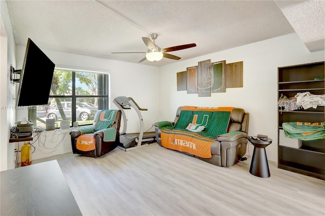 sitting room featuring ceiling fan, a textured ceiling, and light wood-type flooring