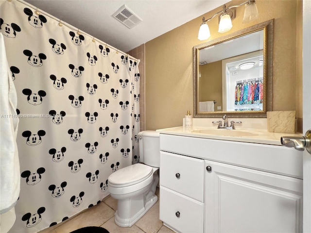 bathroom featuring walk in shower, tile patterned flooring, vanity, and toilet