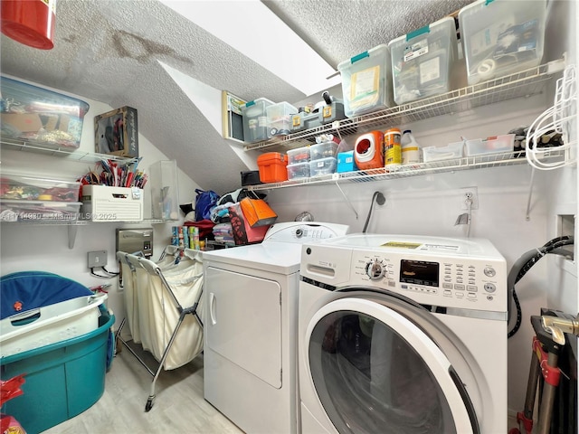 laundry area featuring a textured ceiling and separate washer and dryer