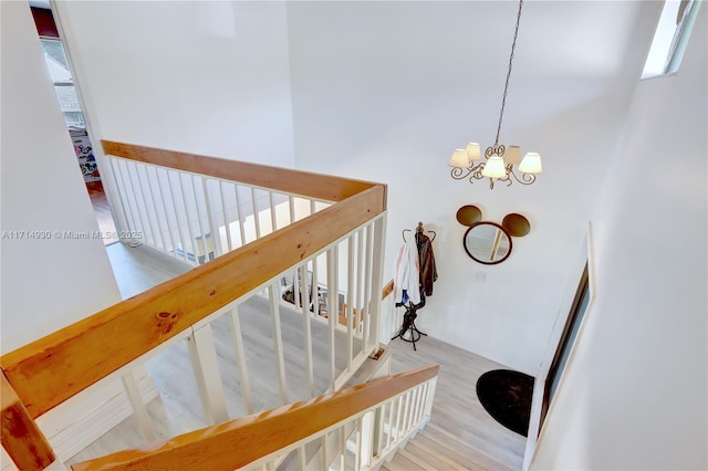 stairway with a chandelier and wood-type flooring