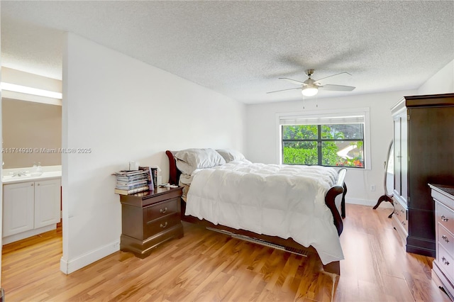 bedroom featuring ceiling fan, ensuite bathroom, and light wood-type flooring