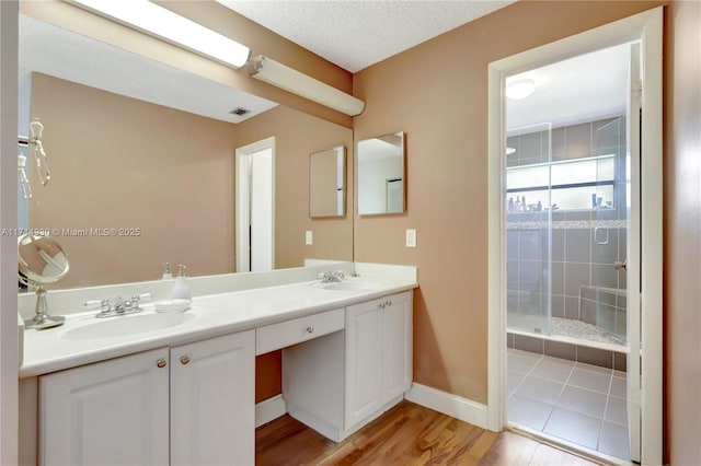 bathroom featuring hardwood / wood-style floors, vanity, and a shower with door