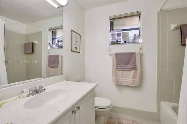 full bathroom featuring vanity, tiled shower / bath combo, and toilet