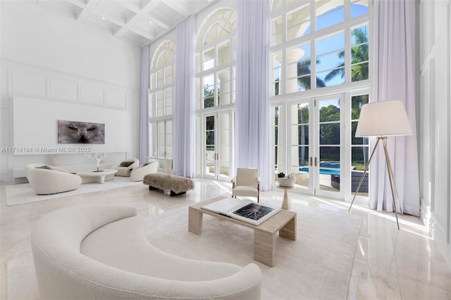 living room with beamed ceiling, french doors, coffered ceiling, and a high ceiling