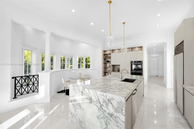 kitchen with light stone countertops, sink, stainless steel double oven, a spacious island, and decorative light fixtures