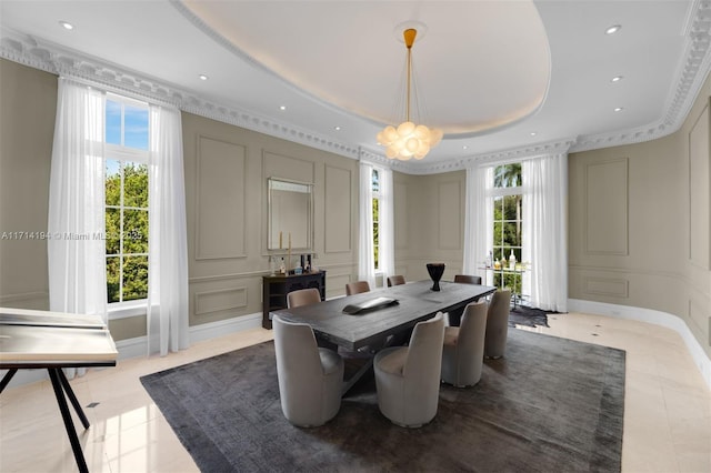 tiled dining space featuring a raised ceiling, a wealth of natural light, and an inviting chandelier