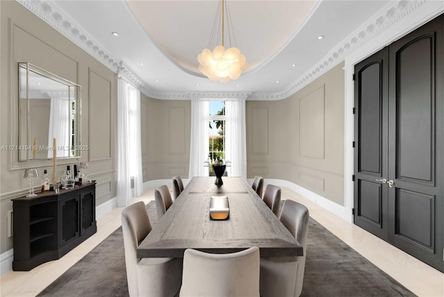 dining area with an inviting chandelier and a tray ceiling