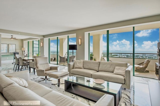 living room with ceiling fan and a water view