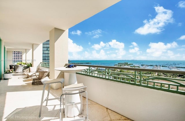 balcony with a water view and a view of the beach