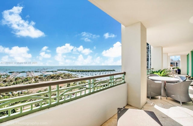 balcony with a water view and a view of the beach