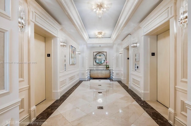 corridor with elevator and a tray ceiling