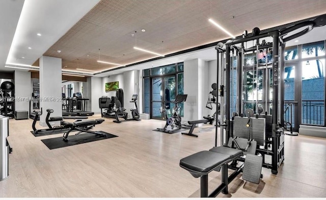 gym with expansive windows and light hardwood / wood-style floors