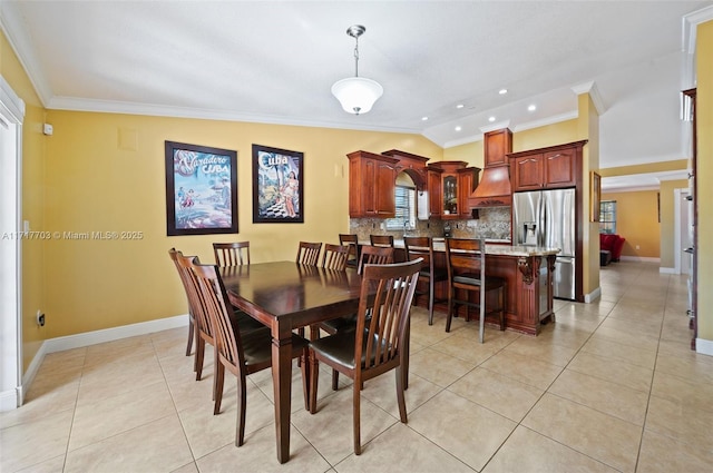 tiled dining room featuring ornamental molding and lofted ceiling