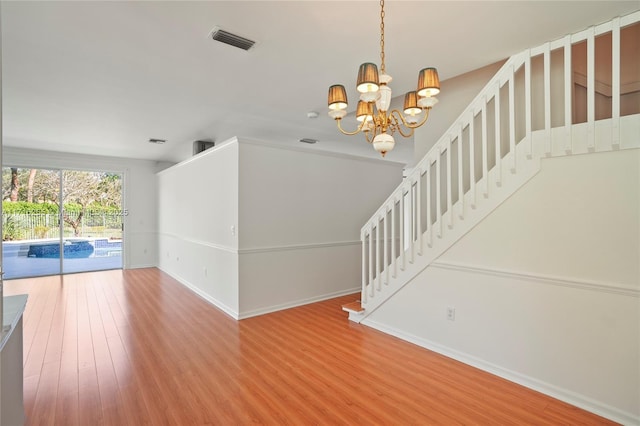 unfurnished living room featuring hardwood / wood-style flooring and a notable chandelier