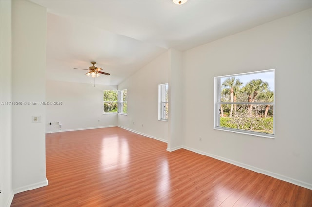 empty room featuring ceiling fan, lofted ceiling, and light hardwood / wood-style flooring