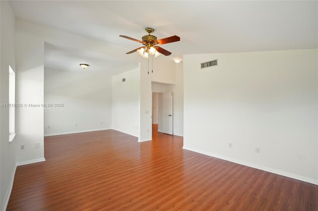 empty room with hardwood / wood-style flooring, ceiling fan, and vaulted ceiling