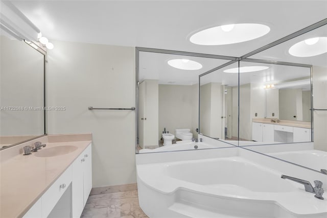 bathroom featuring a tub to relax in, vanity, and toilet