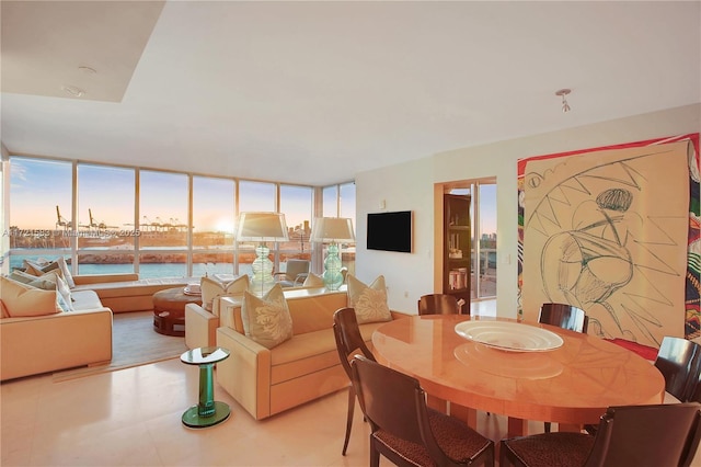 dining area featuring a water view and a wall of windows