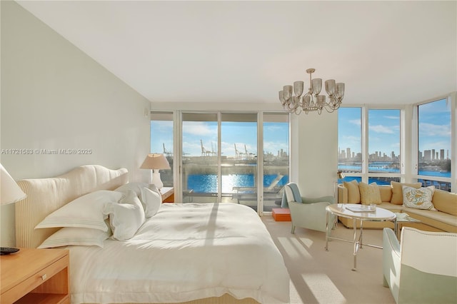 bedroom featuring a water view, light colored carpet, and a chandelier