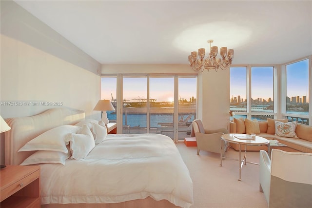 bedroom featuring light carpet, access to outside, a water view, and an inviting chandelier