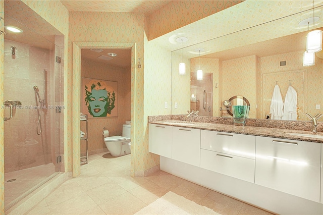 bathroom featuring tile patterned floors, vanity, toilet, and a shower with door