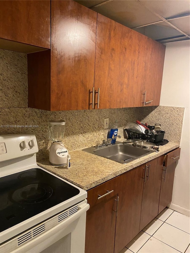 301 NW 177th St Unit 119, Miami Gardens, FL 33169 - kitchen featuring decorative backsplash, sink, white range with electric stovetop, and light tile patterned flooring