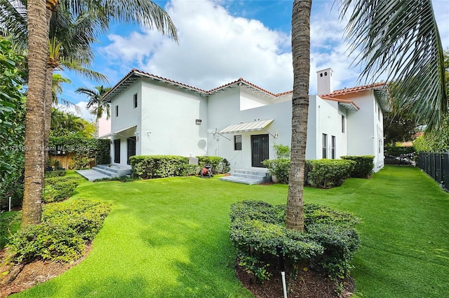 rear view of property with a yard