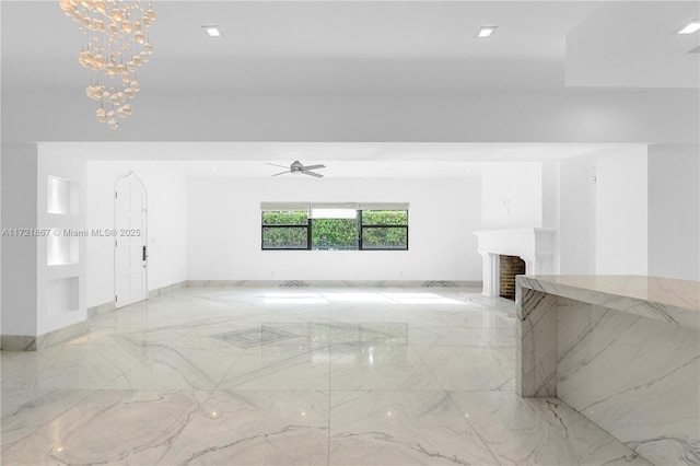 unfurnished living room with ceiling fan with notable chandelier