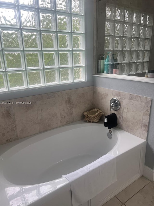 bathroom featuring tiled bath and tile patterned flooring