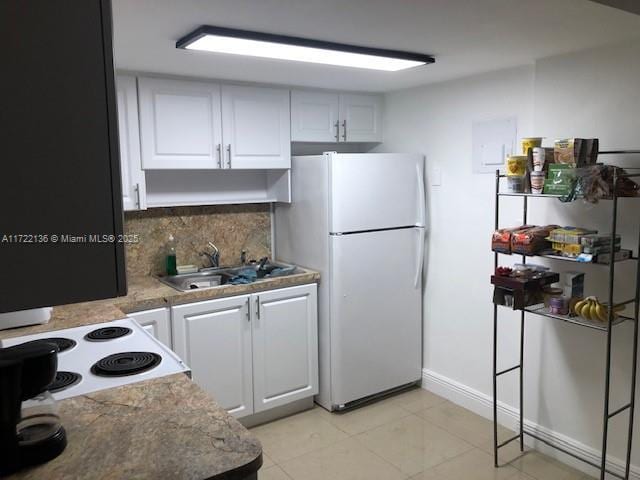 kitchen with white fridge, white cabinetry, tasteful backsplash, and sink