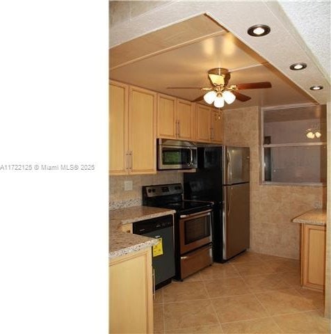 kitchen with ceiling fan, light brown cabinetry, light tile patterned flooring, and black appliances