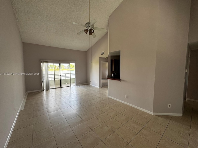 spare room featuring light tile patterned floors, a textured ceiling, high vaulted ceiling, and ceiling fan