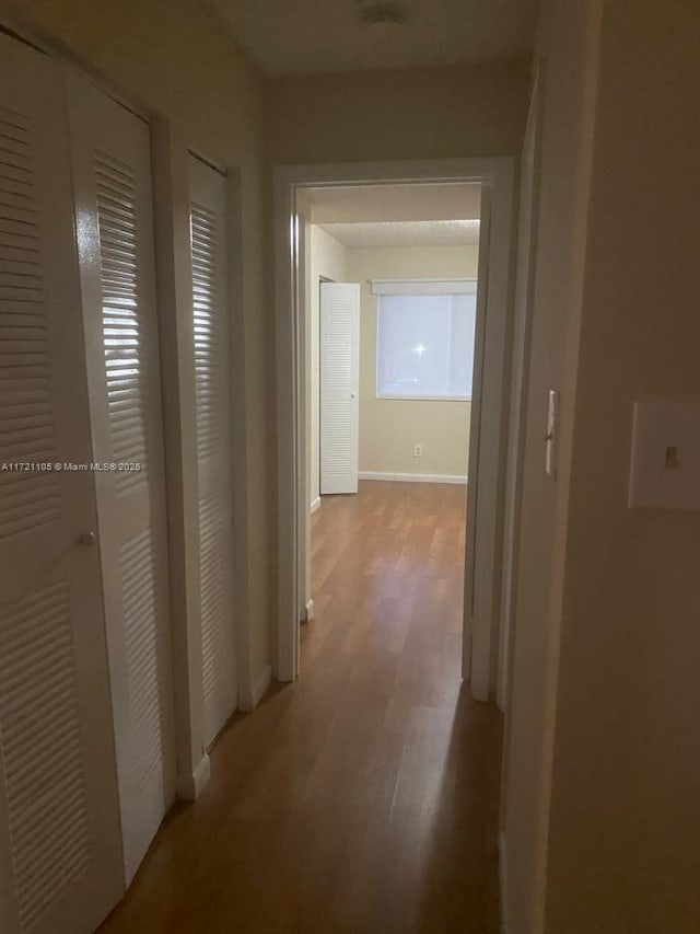 corridor with wood-type flooring