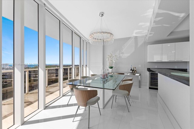 dining room featuring expansive windows, light tile patterned floors, beverage cooler, and a chandelier