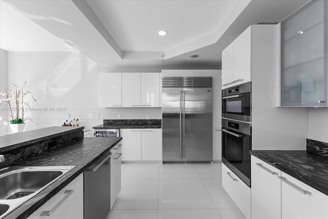 kitchen with sink, white cabinetry, stainless steel appliances, and light tile patterned floors