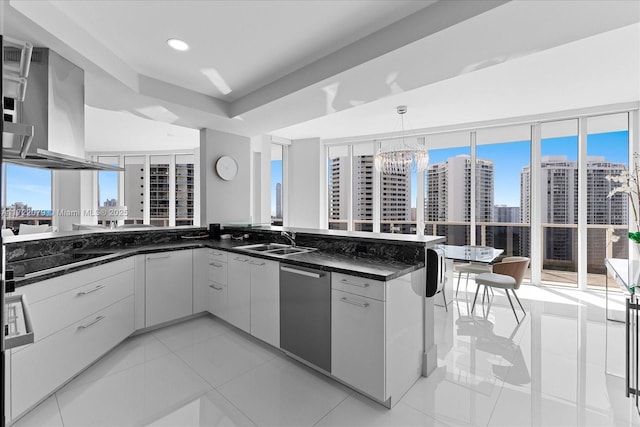 kitchen with stainless steel dishwasher, sink, decorative light fixtures, stovetop, and white cabinetry