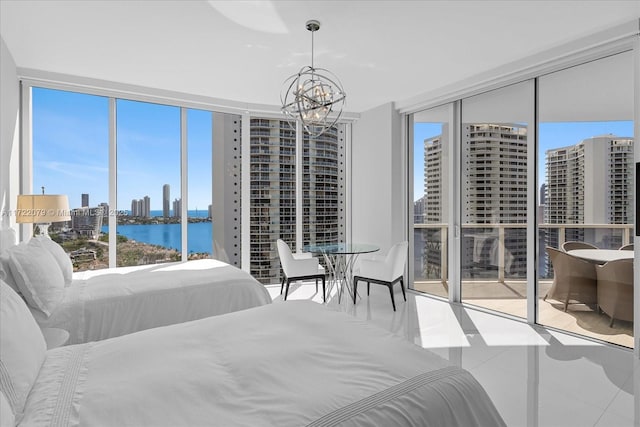 bedroom featuring tile patterned flooring, expansive windows, a notable chandelier, access to outside, and a water view