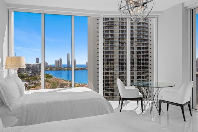 bedroom featuring a water view, a wall of windows, and multiple windows