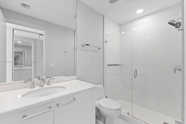 bathroom with vanity, toilet, and a shower with door